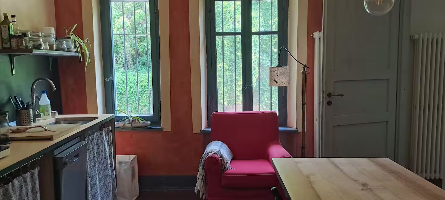 Angolo lettura in cucina con poltroncina rossa