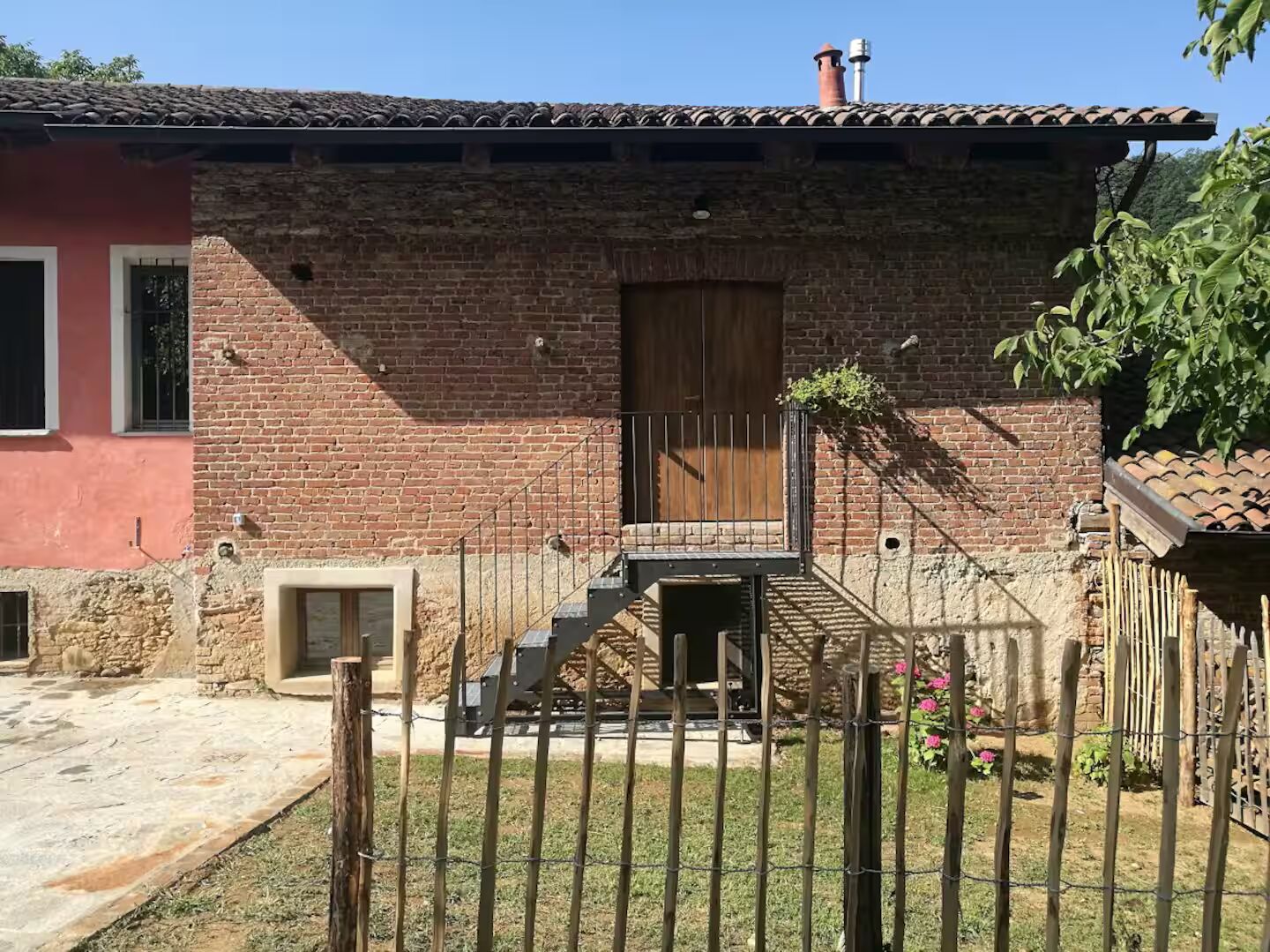 Facciata della cascina Le case di Dona, tra il verde della collina torinese