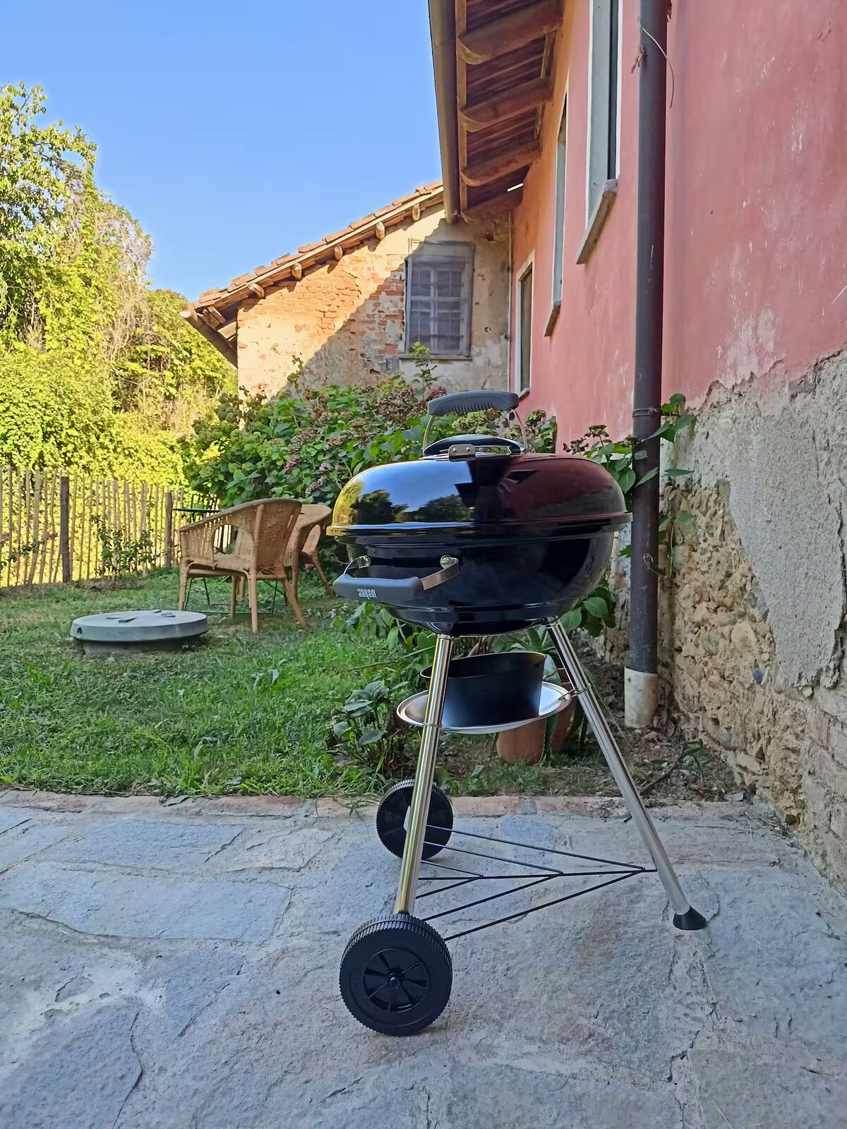 Giardino con barbecue e sedute in vimini
